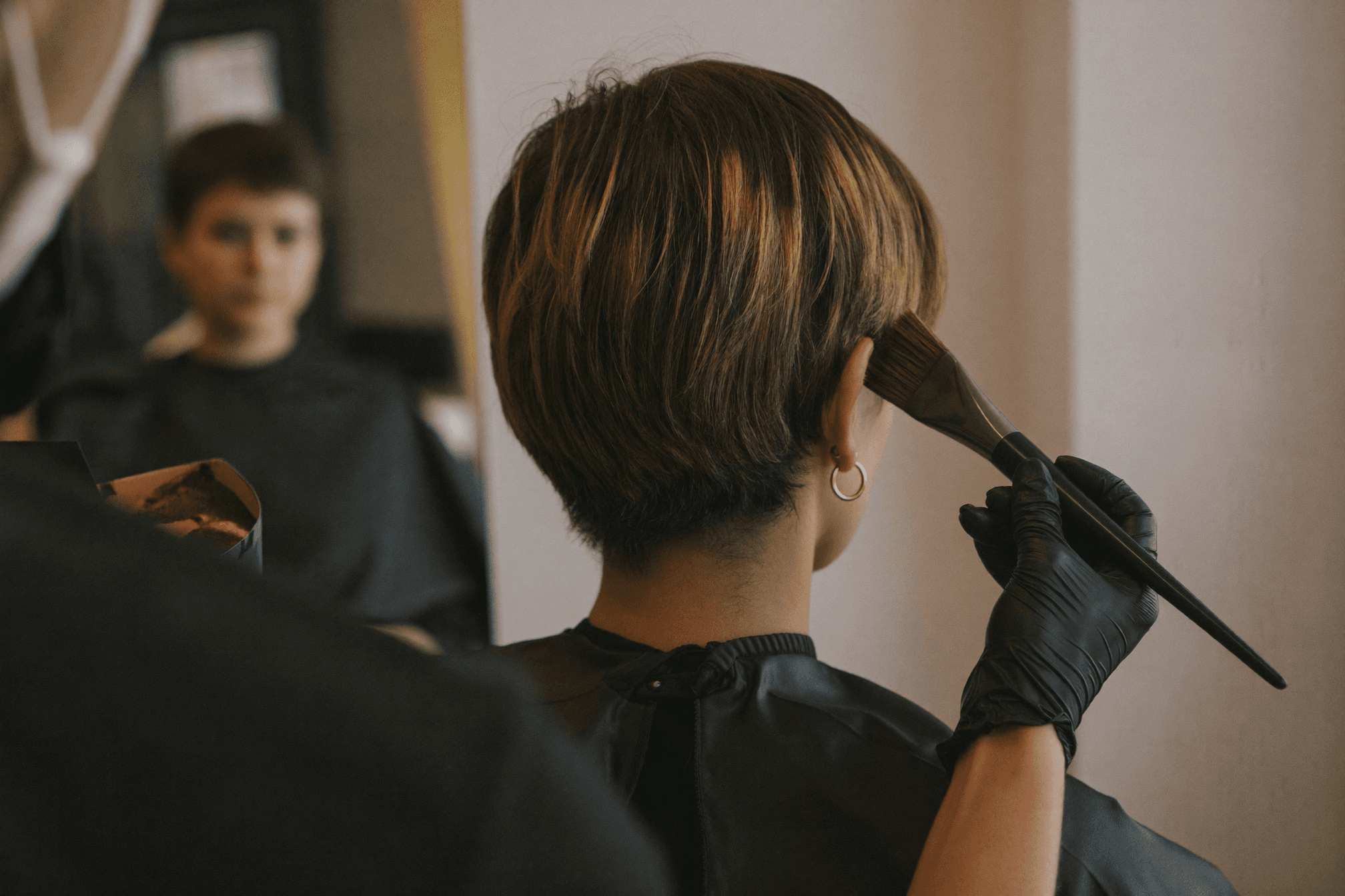 Farbauftrag mit dem Pinsel auf kurzem Haar im Salon